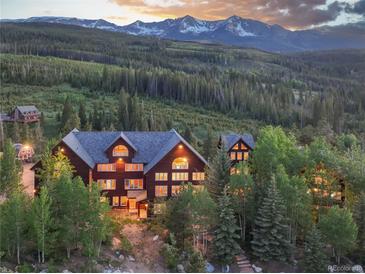 Stunning exterior view of a mountain home surrounded by lush trees and a breathtaking mountain backdrop at 300 Gold Hill Rd, Breckenridge, CO 80424