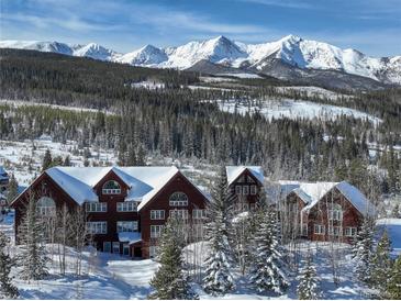 Stunning exterior of a mountain home with snow-covered roof and backdrop of snow-capped peaks at 300 Gold Hill Rd, Breckenridge, CO 80424