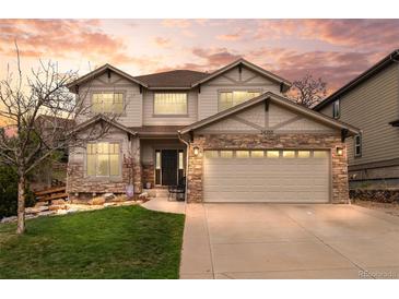 Inviting two-story home showcases stone accents, neutral siding, manicured lawn and an attached two car garage at 24355 E Briarwood Ave, Aurora, CO 80016