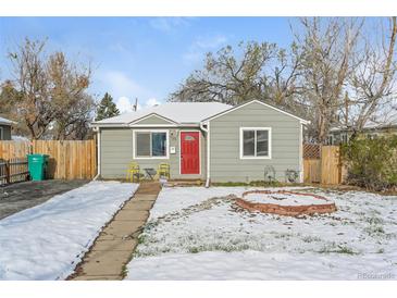 Charming home with a red front door, snowy yard, and quaint seating area at 1125 Newark St, Aurora, CO 80010