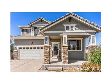 Two-story house with gray siding, stone accents, and a two-car garage at 17 Ellendale St, Castle Rock, CO 80104