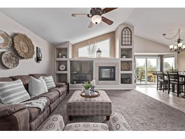 Inviting living room features built-in shelving, a cozy fireplace, and stylish decor accents at 14713 Josephine St, Thornton, CO 80602