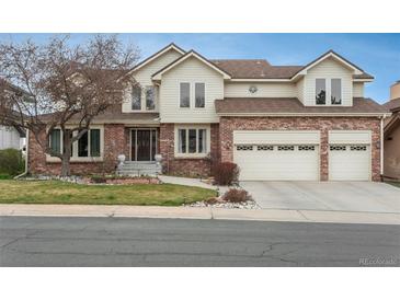 Charming two-story home features a brick facade, manicured lawn, and attached two car garage at 7965 S Eudora Cir, Centennial, CO 80122