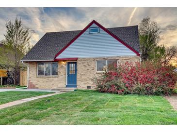 Charming brick home with a well-maintained lawn, vibrant foliage, and a pop of color from the blue front door at 3745 Fairfax St, Denver, CO 80207