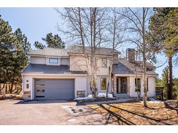 Charming home with stone accents, well-maintained landscaping, and a two-car garage offers curb appeal at 2122 Cramner Ct, Evergreen, CO 80439
