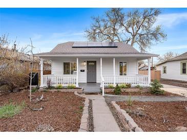 Charming home featuring a covered porch, solar panels, and a meticulously landscaped front yard at 1623 Dayton St, Aurora, CO 80010