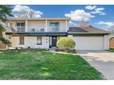 Charming two-story home with a front yard and a covered balcony providing inviting curb appeal at 6660 E Floyd Ave, Denver, CO 80224