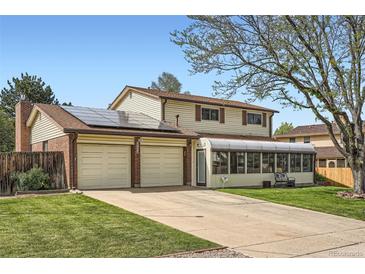 Charming two-story home with a long driveway, a two-car garage, and a sunroom at 10223 W 77Th Dr, Arvada, CO 80005