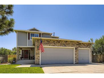 Charming home featuring a stone-accented, attached two-car garage and well-maintained lawn at 4276 S Tempe Ct, Aurora, CO 80018