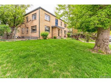 Charming brick building with a lush green lawn and mature trees, providing a serene outdoor setting at 1182 Clermont St # A202, Denver, CO 80220