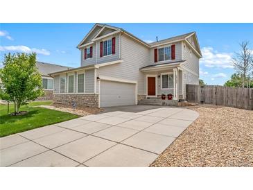 Charming two-story home with a well-maintained front yard, concrete driveway, and an attached garage at 13152 E 104Th Dr, Commerce City, CO 80022