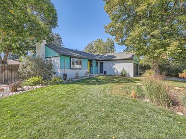 Ranch home with teal siding, white brick, and a landscaped lawn at 879 S Hudson St, Denver, CO 80246