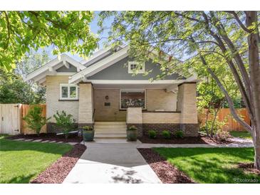 Charming brick home with a covered front porch and well-manicured landscaping at 650 Saint Paul St, Denver, CO 80206