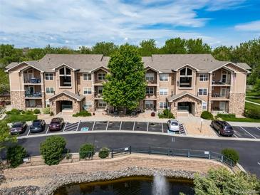 Beautiful condo building featuring well-maintained landscaping, pond, and ample parking for residents and guests at 10787 Twenty Mile Rd # 205, Parker, CO 80134