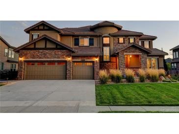 A stunning stone-accented home with a well-maintained lawn and a three-car garage at 1440 Eversole Dr, Broomfield, CO 80023