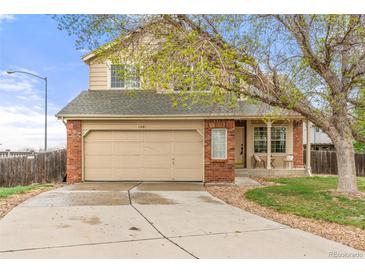 Charming two-story home features a brick facade, two-car garage, and inviting front porch with seating area at 1261 E 135Th Pl, Thornton, CO 80241