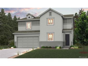 Charming two-story home features a well-maintained lawn, two-car garage and welcoming entrance at 1416 Orchard St, Brighton, CO 80601