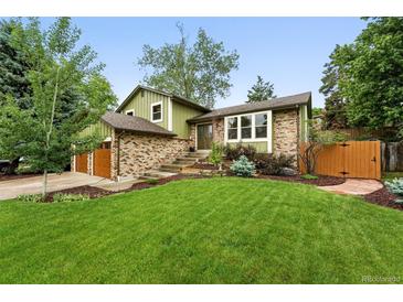 Charming two-story home featuring a brick facade, lush lawn, and inviting landscape at 6248 E Mineral Pl, Centennial, CO 80112