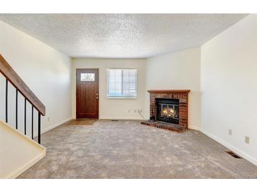 Cozy living room featuring a brick fireplace and neutral carpeting at 17102 E Baltic Dr # F, Aurora, CO 80013