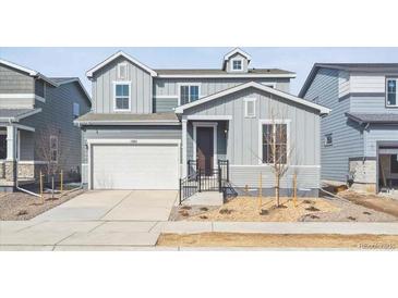 Charming two-story home with gray siding, an attached garage, and well-maintained landscaping at 1385 Bloom St, Brighton, CO 80601
