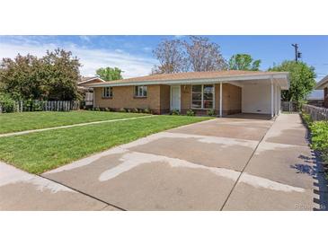 Single story home featuring a brick facade, covered parking and mature landscaping at 4728 Dover St, Wheat Ridge, CO 80033
