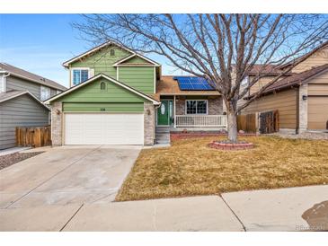 Charming two-story home featuring a well-manicured lawn and welcoming front porch at 3811 E 138Th Pl, Thornton, CO 80602