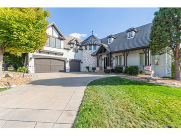 Stunning home showcasing a turret entrance, charming landscaping, and attached garage with circular driveway at 618 Fairchild Dr, Highlands Ranch, CO 80126