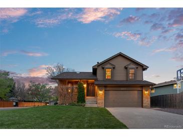 Charming two-story home featuring a well-manicured lawn, brick accents, and a two-car garage at 12017 W Cross Dr, Littleton, CO 80127
