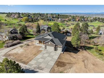 Stunning two-story home with a three-car garage and professionally designed concrete driveway and lush green landscaping at 7778 Windwood Way, Parker, CO 80134