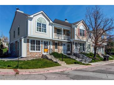 Charming multi-level townhouse with a stone and siding exterior, landscaping, and inviting front entrances at 9565 W Coal Mine Ave # A, Littleton, CO 80123