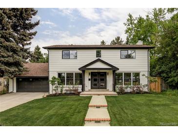 Charming two-story home with manicured lawn, lush trees, and inviting entryway at 3930 S Hillcrest Dr, Denver, CO 80237