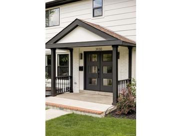 Charming entryway featuring a modern black double door, brick accents and a covered porch at 3930 S Hillcrest Dr, Denver, CO 80237