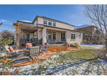 Backyard patio with pergola, outdoor seating and firepit on a sunny day at 2272 Front Range Rd, Erie, CO 80516