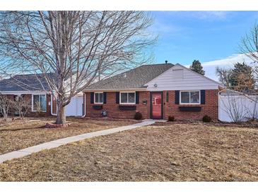 Charming brick home with a well-maintained lawn, sidewalk, and a lovely tree in the front yard at 1680 Syracuse St, Denver, CO 80220