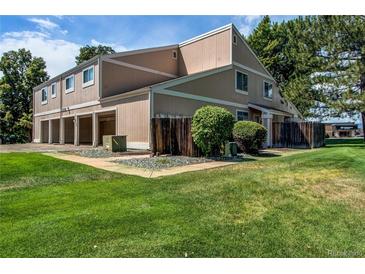 A charming townhouse with a well-manicured lawn, wooden fence, and access to the garage at 8798 Chase Dr # 2, Arvada, CO 80003