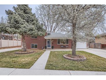 Charming brick home with a well-manicured front yard and beautiful, mature trees at 6970 Upham St, Arvada, CO 80003