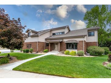 Charming home featuring manicured lawn and mature trees under a bright sky at 8160 W Phillips W Ave, Littleton, CO 80128
