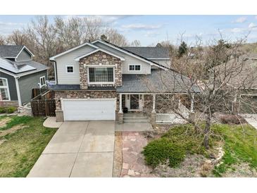 Charming two-story home featuring a stone facade, covered porch, and well-maintained front yard at 5986 Dunraven Ct, Golden, CO 80403