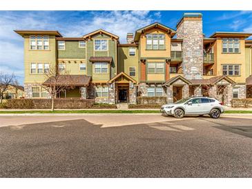 Attractive condo building with colorful siding, stone accents, and well-maintained landscaping at 15455 Canyon Rim Dr # 304, Englewood, CO 80112