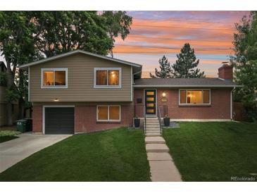 Charming brick home with a well-manicured lawn and colorful sunset backdrop at 6320 E Asbury Ave, Denver, CO 80224