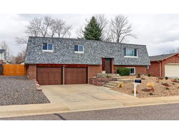 Charming brick home featuring a two-car garage and a well-maintained landscaped front yard at 10679 Union Way, Broomfield, CO 80021