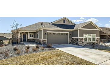 Charming single-story home with a gray exterior, complemented by a stone-accented facade and a spacious two-car garage at 12708 Tamarac St, Thornton, CO 80602