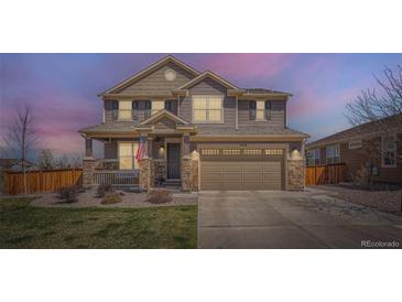 Charming two-story home with a covered porch, stone accents, and a well-manicured lawn at 9574 Keystone Trl, Parker, CO 80134