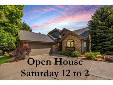 Charming home exterior featuring stone accents, a well-maintained lawn, and a two-car garage, with open house signage at 9 Roder Gate Ln, Castle Pines, CO 80108