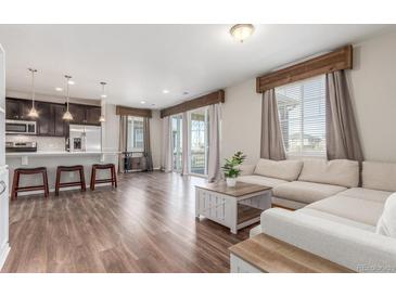 Bright, open-concept living room featuring wood floors, modern decor, and a seamless flow to the kitchen at 22921 E Union Ave, Aurora, CO 80015