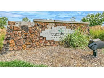 Stone entrance sign to Turnberry community with landscaping, and sunny sky at 13458 E 111Th Ave, Commerce City, CO 80022