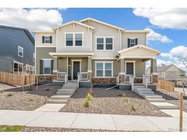 Charming two-story home featuring a welcoming porch, stone accents, and a well-maintained front yard at 13458 E 111Th Ave, Commerce City, CO 80022