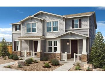 Two-story craftsman style home with gray siding, stone accents, and a front porch at 13458 E 111Th Ave, Commerce City, CO 80022