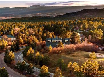 Beautiful exterior view of a home surrounded by lush green trees and mountain views at 7332 Woodglen Pl, Castle Pines, CO 80108