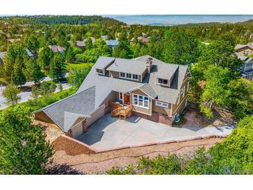 Well-maintained two-story home featuring mature landscaping and a concrete driveway at 7332 Woodglen Pl, Castle Pines, CO 80108